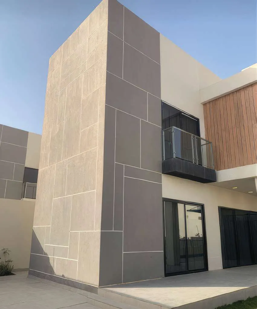 واجهة فيلا حديثة بتكسيات حجرية وزجاج بعد التشطيب